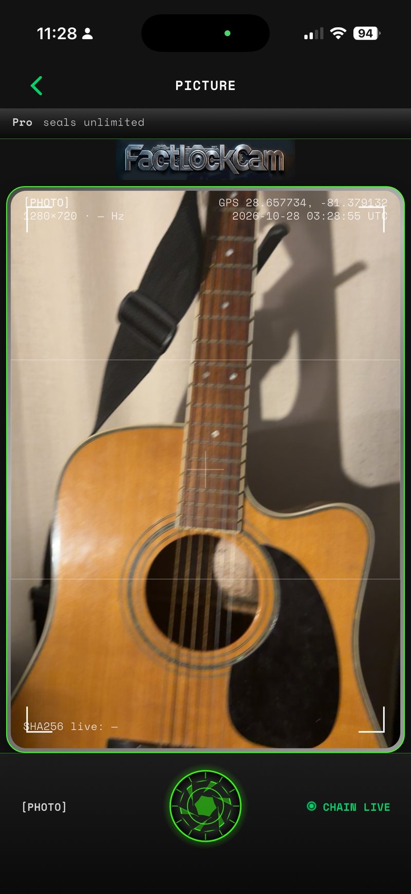 The FactLockCam camera screen on an iPhone, framing a guitar, with GPS, UTC time and Chain Live readouts.